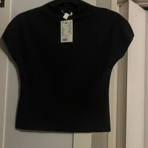 Svart polotopp - Snygg svart polotopp med korta ärmar. Helt ny 