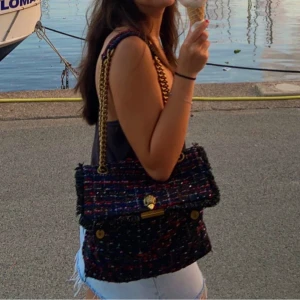 Märkesväska Kurt Geiger - Snygg axelväska från Kurt Geiger. Flerfärgad men främst svart med lite glitter. Kommer tyvärr inte längre till användning. Inga märken eller fläckar. Köpt för 1,5 år sedan på Zalando för 2000kr. Dustbag medföljer!! 