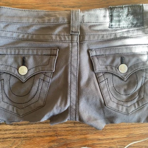 As snygga True religon Grå shorts med fickdetaljer - Snygga grå shorts med fickor och knappar. De är typ mid-low waist design och är gjorda i ett mjukt jeans material .