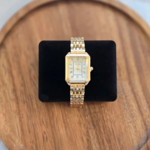 Guldfärgad klocka från Jusmi - Elegant guldfärgad klocka från Jusmi med rektangulär urtavla och romerska siffror. Klockan har en klassisk länkarmband i guld och en vit urtavla som ger en tidlös look. Perfekt för att lägga till en touch av lyx till din stil. Klocka funkar som den ska och absolut inga täcken på användning💕