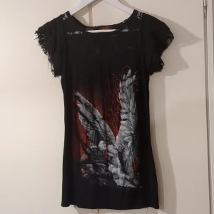 Svart topp med spetsdetaljer och tryck från Spiral Direct - Topp med ängel print, mycket stretch