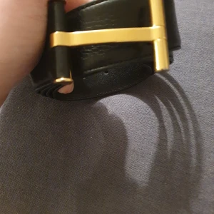  tom ford Svart skärp med guldfärgat spänne - Elegant svart skärp i skinn med ett stilrent guldfärgat spänne. Perfekt för att ge en lyxig touch till din outfit. Skärpet har en klassisk design som passar till många olika stilar.size 100/40 original off course