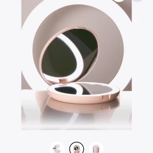 Rund sminkspegel med LED-belysning från By Lyko - Elegant rund sminkspegel i en ljusrosa nyans med inbyggd LED-belysning för perfekt ljus vid sminkning. Spegeln är kompakt och lätt att ta med i väskan, perfekt för touch-ups under dagen. Den har en stilren design och är enkel att använda. Laddare kommer till såklart!