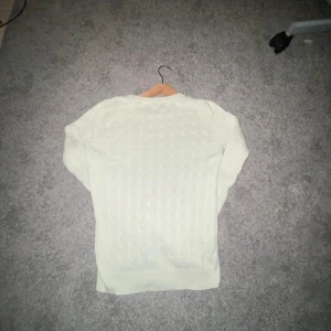  stickad tröja från Morris - Säljer en stilren stickad tröja från Morris med ett klassiskt flätmönster. Tröjan har rund hals och långa ärmar, perfekt för kyligare dagar. En tidlös design som passar till många tillfällen. NY PRIS 1600kr