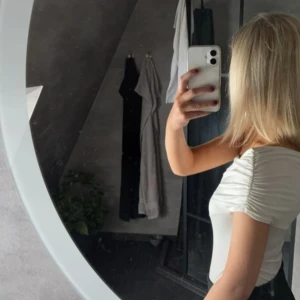 Vit oneshoulder topp - Säljer en stilren vit oneshoulder body med en tight passform. Perfekt för en elegant look. Toppen har en enkel design som framhäver axeln och ger en modern touch. Prislapp kvar 