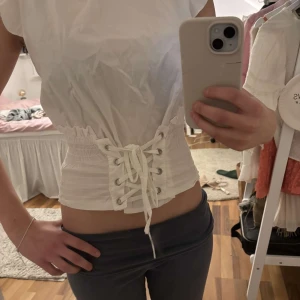 Vit korsett-topp med snörning - Säljer en stilren vit korsett-topp med snörning i midjan. Har ingen lapp men passar XS-S🧡