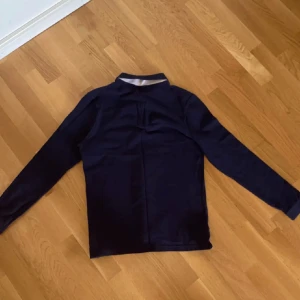  Pikétröja från Ralph Lauren - Säljer en stilren mörkblå pikétröja från Ralph Lauren med klassisk krage och knappar framtill. Storlek S Använd bara några fåtal gånger. Pris kan diskuteras vid snabb affär 