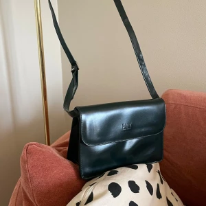 Crossbodybag  - Crossbodybag i syntetskinn. Ser ut att vara helt ny. Mossgrön/mörkgrön i färgen.