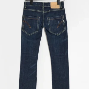 Mörkblå jeansbyxor - Snygga mörkblå jeansbyxor med kontrastsömmar och klassisk femficksdesign. Perfekta för en avslappnad stil. De har en midwaist passform och raka ben som ger en tidlös look.