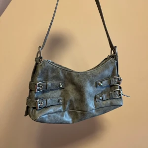 MONKI väska  - Väska från monki med coola detaljer. Säljer pga används ej längre, skicket på väskan är 8/10. Nypris var 299 kr säljs för 95 kr. 