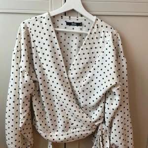 Prickig blus - Jättefin prickig blus som är omlott med snöre som man knyter🎀💕TikToken är när jag har på mig den😜från bikbok storlek M