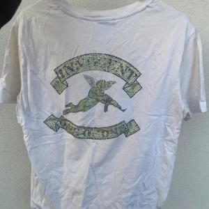 One of one T-shirt  - Vit snygg unisex T-shirt med rhinestones tryck på baksidan. Tyvärr så har några av stenarna lossnat men trycket syns ändå fint. Nypris 500kr och säljs inte längre 😇