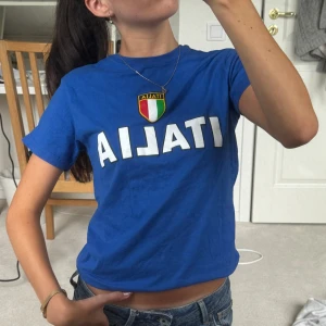Blå t-shirt med Italienskt tryck - Säljer en blå t-shirt m ”italia” på bröstet, topp skick utan defekter 