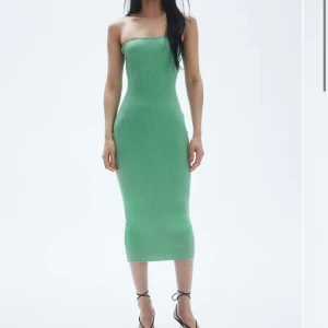 Grön ribbad klänning från H&M - Säljer en superfin grön ribbad klänning från H&M. Den är axelbandslös och har en tight passform som verkligen framhäver figuren. Perfekt för sommarens fester eller en utekväll. Klänningen är i nyskick endast använd en gång och redo att bäras av någon som vill sticka ut!