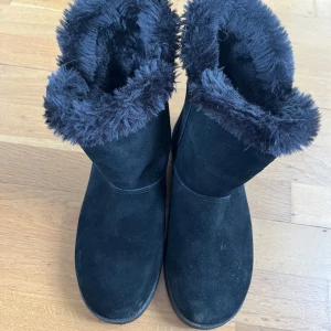 Svarta boots med pälsfoder - Säljer ett par svarta boots med mysigt pälsfoder. De har en dragkedja på sidan för enkel på- och avtagning. Perfekta för kalla vinterdagar!
