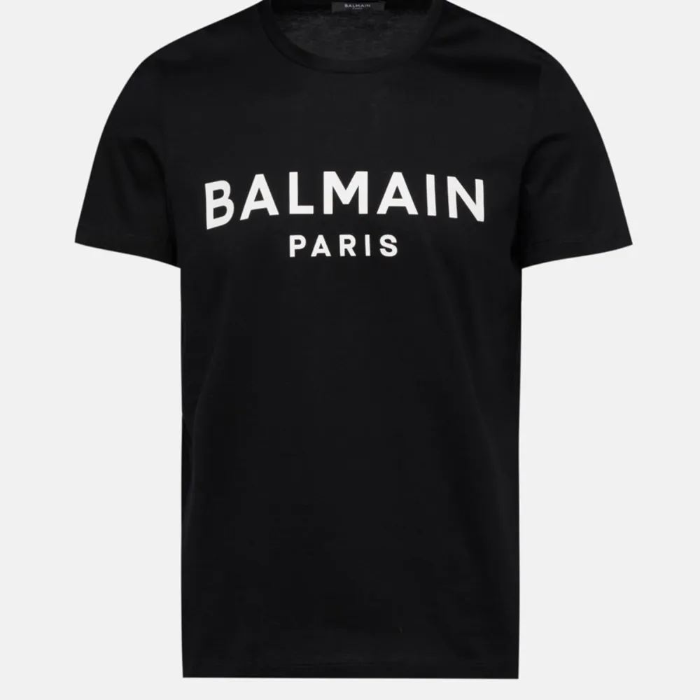 Säljer två snygga t-shirts från Balmain i klassiska färger. Den ena är vit med svart text och den andra är svart med vit text. Båda har korta ärmar och är gjorda i mjuk bomull. Perfekta för en stilren look!. T-shirts.