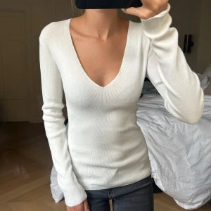Vit tröja  - Säljer denna vita tröja med vringning. Lite ribbad. Sparsamt använd så i väldigt bra skick!💗