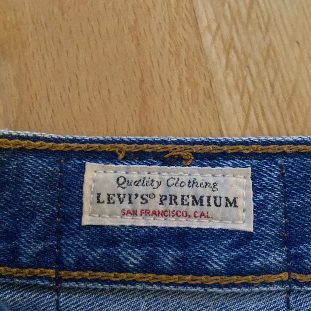 Säljer en snygg blå jeanskjol från Levi's. Kjolen har en klassisk femficksdesign och knappar framtill. Perfekt för en avslappnad och stilren look. Passar både till vardags och fest!. Kjolar.