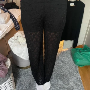 Svarta spetsbyxor - Snygga svarta byxor i spetsmaterial med en elegant look. Perfekta för att ge en stilfull touch till din outfit. Byxorna har en rak passform och är högmidjade för en bekväm känsla.