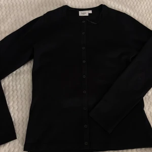Svart kofta från Saint Tropez - Snygg svart kofta från Saint Tropez i storlek S. Den har långa ärmar och knappar hela vägen fram. Aldrig använd 