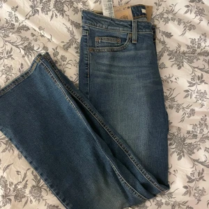 Levi's Superlow Bootcut Jeans - Helt nya med prislappen kvar på. Snygga Levi's Superlow Bootcut jeans i klassisk blå denim. De har en låg midja och bootcut-stil. Storleken är W29 och L32.