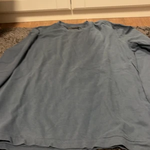 Blå långärmad tröja från Marc O'Polo - Säljer en stilren blå långärmad tröja från Marc O'Polo. Tröjan har en normal passform och är perfekt för en avslappnad look. Tillverkad i mjukt material för extra komfort.