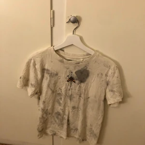 Vit t-shirt med tryck från 157 - Vit t-shirt i bomull från 157 med ett unikt tryck av en fjäril och geometriska former på framsidan. Texten 'Regeneration' finns under trycket. Perfekt för en avslappnad stil.