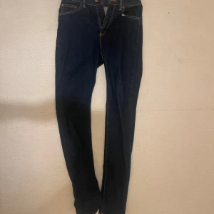 Mörkblå jeans från Nudie Jeans - Snygga mörkblå jeans från Nudie Jeans med klassisk design och orange sömmar. Perfekta för en stilren look. (Helt nya) köpta för 800 