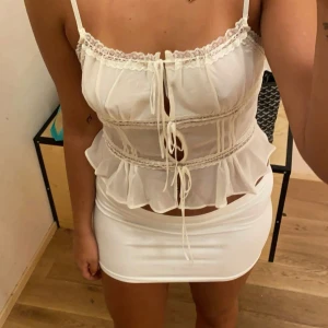 Vit volang topp urban outfitters - Jättefin vit topp från urban outfitters som liknar en gammal topp från Zara väldigt mycket. Knappt använd och storlek M men väldigt liten i passformen, skulle säga att den passar XS/S. Skriv privat för mer info/bilder!❣️