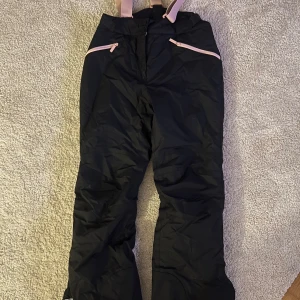 Skidbyxor  - Oanvända skidbyxor, storlek 164. Rosa detaljer