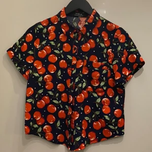  Kortärmad skjorta med körsbärsmönster   - Från Maple. Mörkblå med klarröda körsbär.                 Kolla gärna min profil, säljer mycket nu, allt i fint skick och till bra pris