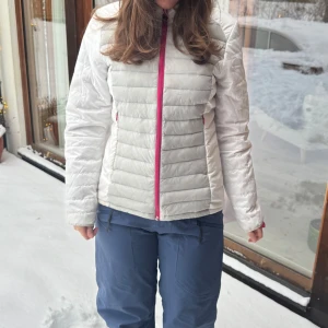 Vit dunjacka/skidjacka med rosa dragkedja - Säljer en såå snygg jacka som jag även använt som skidjacka, med rosa dragkedja och rosa innertyg🩷🩷I superbra skick, skriv om ni har frågor <3 (säljer även massa stickade tröjor från &otherstories, in och kika!!🥰🥰) Storlek 40, jag brukar ha storlek S/M som referens <3