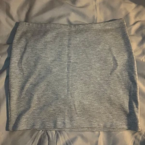 Grå mini kjol från H&M - Snygg och enkel grå kjol från H&M i en klassisk design. Perfekt för en stilren look. Kjolen är i en mjuk och bekväm kvalitet.