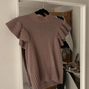 Beige stickad topp med volangärmar - Snygg beige stickad topp med volangärmar och ribbade detaljer. Märket är Holly&Whyte men köpt på lindex. super fin 💓