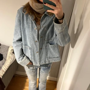 Ljusblå jeansjacka - Säljer en stilren ljusblå jeansjacka med knappar framtill och stora fickor. Helt oanvänd från arket för typ två år sedan. Priset är exkulusivt frakt.