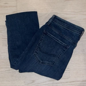 Mörkblå jeans från Jack & Jones - Helt oanvända mörkblå jeans från Jack & Jones med klassisk femficksdesign. De har en knapp och dragkedja framtill. Storlek 32/30 och säljer till ett riktigt bra pris👍 Hör av dig vid funderingar!