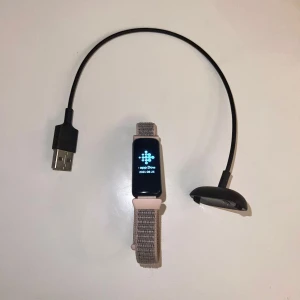 Fitbit Inspire 2 med laddare - Säljer en Fitbit Inspire 2 (aktivitetsarmband) då den inte kommer till användning längre. Har tidigare använt den i perioder för att följa min sömn samt räkna steg. Fungerar felfritt och har inte varit utsatt för vatten eller likande. Laddare ingår och även ett nylonarmband i rosa.