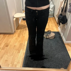 Svarta flare jeans - Snygga svarta flare jeans med låg midja. Perfekta för en trendig look. Tillverkade i en bomullsblandning för komfort och stil. Från Weekday, Storlek W25 L32