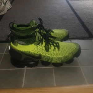 Nike Vapormax i neonfärg - Snygga Nike Vapormax sneakers i en iögonfallande neonfärg med svart snörning. Perfekta för träning eller en sportig vardagslook.