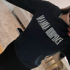 Svart tröja från Emporio Armani - Snygg svart tröja från Emporio Armani med vit logotyp på bröstet. Tröjan har en klassisk rund hals och långa ärmar, perfekt för en stilren look. Köpt i Milano 2019