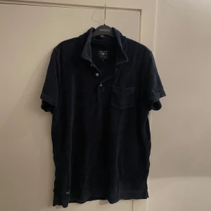 Mörkblå frotté t-shirt från Robbie Moor - Säljer denna  mörkblå pike i frotté från Robbie Moor. Skicket är bra finns inga fel 