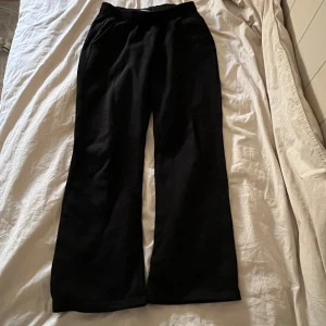 Svarta mjukisbyxor med vid passform - Snygga och sköna svarta mjukisbyxor med en vid passform. Perfekta för en avslappnad stil. De har en elastisk midja för extra komfort.