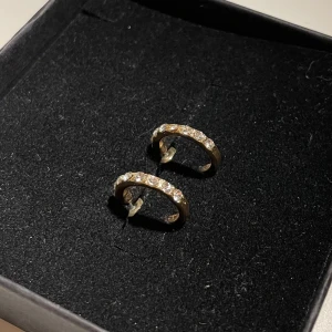 Guldörhängen/złote kolczyki - Snygga guldörhängen med glittrande stenar. Perfekta för att ge en elegant touch till din stil. De är små och diskreta men ändå iögonfallande med sina gnistrande detaljer.