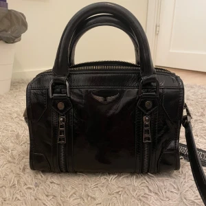 Svart väska från Zadig & Voltaire - Snygg svart handväska i skinn från Zadig & Voltaire med dubbla handtag och en justerbar axelrem, självklart äkta och har kvar både kvitto och äkthetsbevis från vestiare collective ❤️