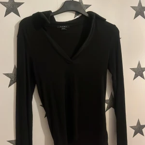 Svart långärmad tröja från Amisu - Säljer en stilren svart långärmad tröja från Amisu. Tröjan har en v-ringad design och är tillverkad i ett mjukt material som ger en bekväm passform. Perfekt för en minimalistisk look.