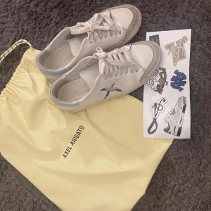 Vita skor, Axel Arigato - Snygga vita sneakers från Axel Arigato, jag säljer på grund av att de ej kommer till användning längre. Säljer för 800kr, nypris 2500kr 