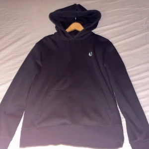 Svart hoodie från Fred Perry - Säljer en stilren svart hoodie från Fred Perry i storlek M. Nypris på dessa hoodies är ungefär 1300-1600 just denna modell säljs ej längre. Jättebra skick använd endast en gång mitt pris 699kr kom gärna med prisförslag. Den passar folk mellan 185-195 skulle jag säga. Hör av er vid funderingar. Är även öppen för byten