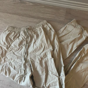 Beige tyg byxor - Byxorna är använda ett fåtal gånger behöver strykas annars märks inga defekter. Skriv gärna vid frågor eller om du vill ha fler bilder.