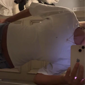 Vit kortärmad topp med knyt - Snygg topp från Nelly använd ett fåtal gånger.