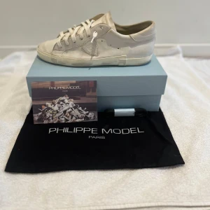 Vita sneakers från Philippe Model - Säljer ett par Philippe Mosel skor i bra skick. Dust jag finns med, original kartong och extra snören. Stilrena med snygga detaljer tveka inte att höra av dig om du har frågor. Kan gå ner lite i pris.